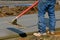 Bull float being used on a freshly poured sidewalk