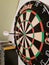 Bull`s eye with a dart on a board which scores 50 points in a game.