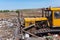 A bulldozer clears heaps of garbage in a garbage can. Work bulldozer in a landfill