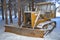 Bulldozer covered with snow in forest