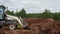 Bulldozer drives to pour dirt into trench with yellow pipe