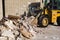 Bulldozer excavator shoveling debris into pile with his ladle