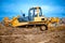 Bulldozer or excavator working with soil on construction site