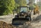 Bulldozer, forklift and workers at the construction road junction in Moscow