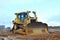 Bulldozer during of large construction jobs at building site. Crawler tractor dozer for earth-moving.