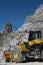 Bulldozer. Large white marble quarry with blue sky background