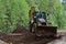 Bulldozer leveling sand piles on a country road