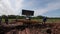 Bulldozer lifts up pipe in casing from trench against sky