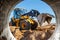 Bulldozer or loader moves the earth at the construction site against the blue sky. An earthmoving machine is leveling the site.