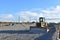 Bulldozer moves gravel during on road work at construction site. Dozer leveling stones for laying asphalt on a new freeway. Heavy