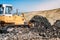 Bulldozer moving garbage with scoop. Industrial construction details