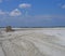 bulldozer pushes sand on blue sky background