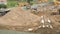 Bulldozer working on large pile of sand in summer