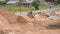 Bulldozer working on large pile of sand in summer