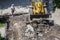 Bulldozer works on the repair of the intra-block road and sidewalk