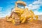 Bulldozer yellow colored standing on sand rear