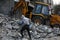 Bulldozers remove the debris from the  building, that was hit by Israeli air strikes during the Israeli-Palestinian conflict in Ma