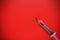 Bullet in a disposable syringe on a red background