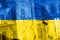 Bullet hole, cracks in the glass on a yellow-blue background. Ukraine flag on broken glass texture. Concept, Russian-Ukrainian war