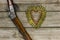 Bullets in the shape of heart next to rifle on rustic wooden background
