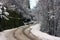 Bumpy and poorly paved road trail on mountain winter snow white dirt trail in forest