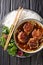 Bun cha is a Vietnamese dish of grilled pork, noodle and herb closeup in the plate. Vertical top view