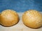 Bun with sesame seeds. Table in the bakery. White bun on a cutting board. Products made from wheat flour of the highest grade