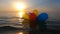 Bunch airy multi-colored balloons swing waves sea sunny summer day sunset Dawn