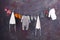 Bunch of baby\'s clothes hanging on a string with clothespins on a grungy background