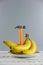 Bunch of bananas and hammer on wooden background. Copy space for text or logo. Vertical shot