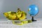 Bunch of bananas,measuring tape, and globe on wooden background