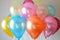 A bunch of brightly colored balloons effortlessly float in the air against a blue sky backdrop, Assorted latex balloons for a