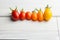 Bunch of Cherry tomatoes in a row for color nuance on white wood background