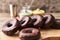 Bunch of chocolate doughnuts on a wooden surface