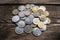 Bunch of coins on the aged rough wooden windowsill.