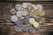 Bunch of coins on the aged rough wooden windowsill.