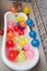 Bunch of colorful balloons in bath tube. Large pile of multicolored inflated balloons