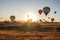 Bunch of colorful hot air balloon flying early morning against sunrise in Cappadocia, Turkey against typical rock formation due to