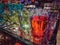 Bunch of colourful glass tea cups clustered together on a glass table in a home decoration shop .