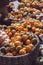 Bunch of decorative mini pumpkins and gourds in baskets on farmers market; autumn background