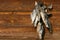 A bunch of dried salted fish hangs on a background of wooden planks