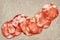 Bunch of Eight Pork Salami Slices Set On Rustic Vintage Parchment Place Mat Grunge Surface