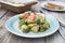 Bunch of fresh Bruxelles sprouts in plate on rustic wooden background. Healthy food.