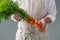 Bunch of fresh carrots in manâ€™s hands.