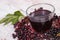 Bunch of fresh elderberry with juice on old wooden background, healthy nutrition