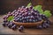 Bunch of fresh grapes on wooden table. Vintage style toned picture. ai generative