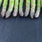 Bunch of fresh green asparagus on  dark slate background, square format, copy space
