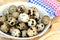 A bunch of fresh little spotted quail eggs in a bowl