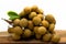 Bunch of fresh Longan Dimocarpus longan on wooden board with white background.