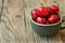 Bunch of fresh ripe colorful glossy sweet cherries in ceramic tea cup on wood background, minimalist, copy space for text